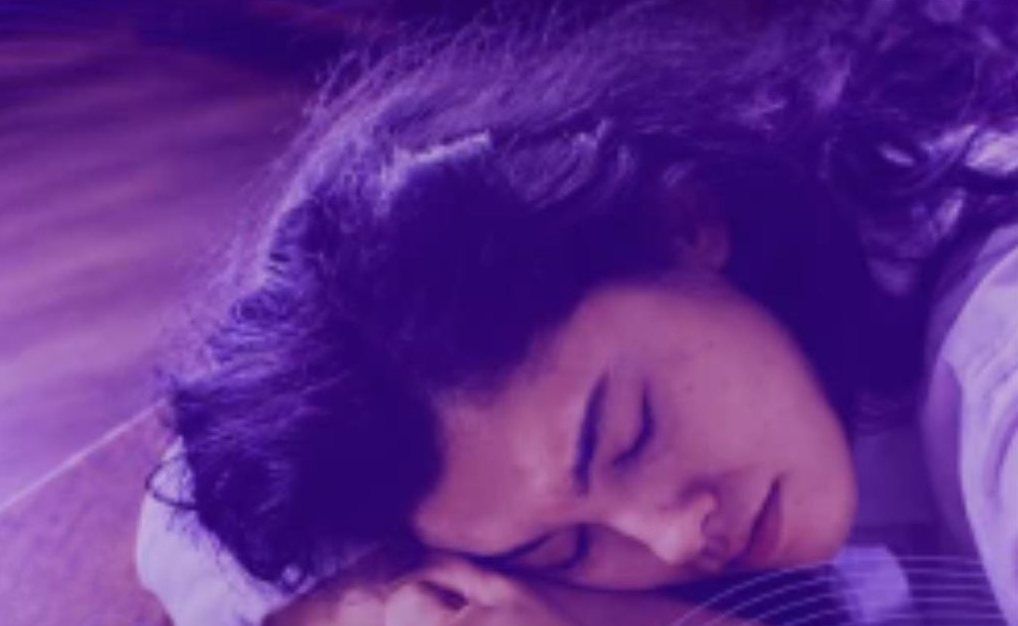 Woman resting her head on her arms, eyes closed
